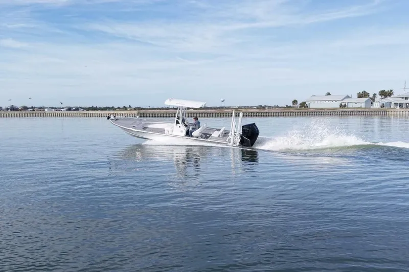 Slide: The Image of 2023 Haynie 25 Magnum boat cruising on calm waters under a clear sky. - 9