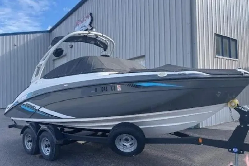 The Image of 2020 Yamaha AR210 boat on trailer, parked outside a metal building. - 1