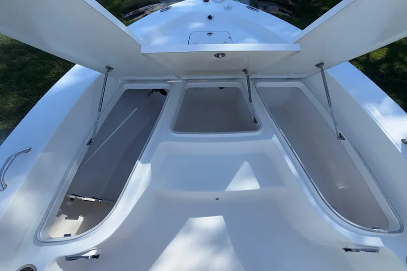 Slide: The Image of 2018 Robalo 226 Cayman boat storage compartments open, showcasing spacious interior design. - 10