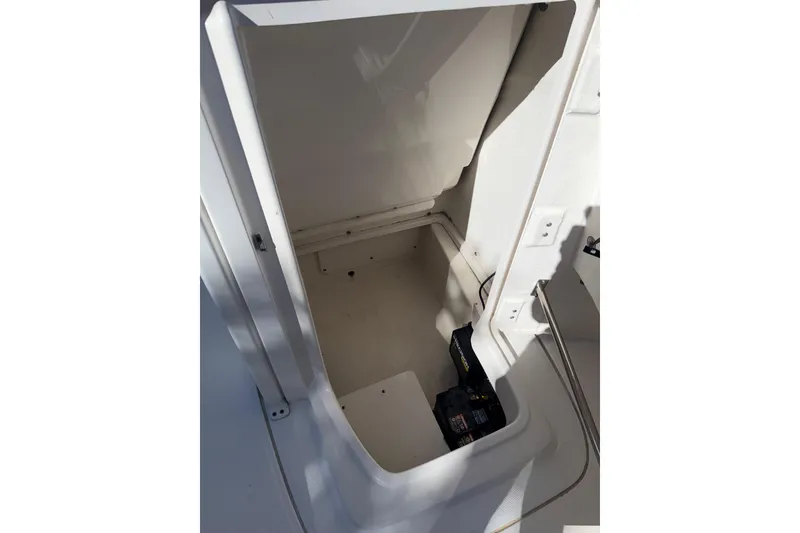 Slide: The Image of 2018 Robalo 226 Cayman boat storage compartment with battery visible. - 14