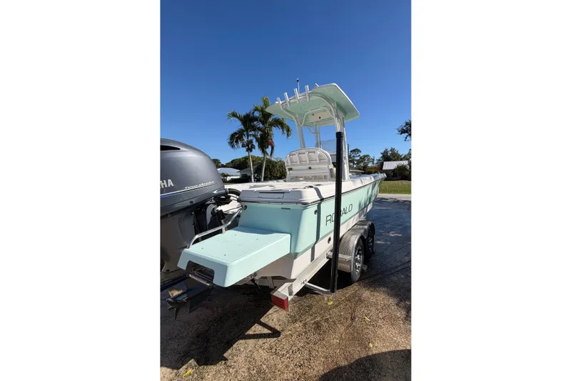 Slide: The Image of 2018 Robalo 226 Cayman boat on trailer, parked outdoors under clear blue sky. - 4