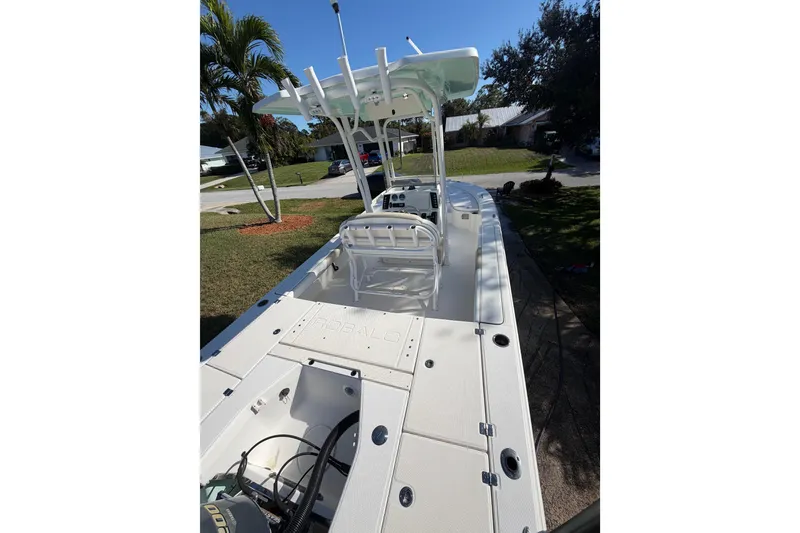 Slide: The Image of 2018 Robalo 226 Cayman boat with spacious deck and seating, parked outdoors. - 8