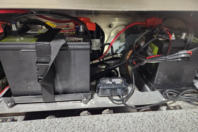 Slide: The Image of Battery compartment of 2024 Hewescraft 180 Sportsman with wiring and charger. - 13