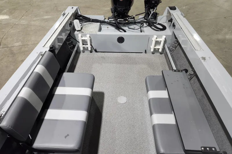 Slide: The Image of 2024 Hewescraft 180 Sportsman boat interior with gray seating and dual outboard motors. - 7
