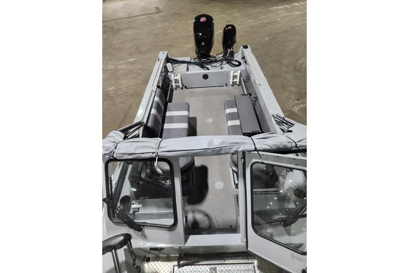 Slide: The Image of 2024 Hewescraft 180 Sportsman boat interior with seating and dual outboard motors. - 9