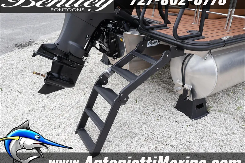 Slide: The Image of 2026 Bentley Pontoons Elite 223 Swingback with motor and ladder on gravel. - 8