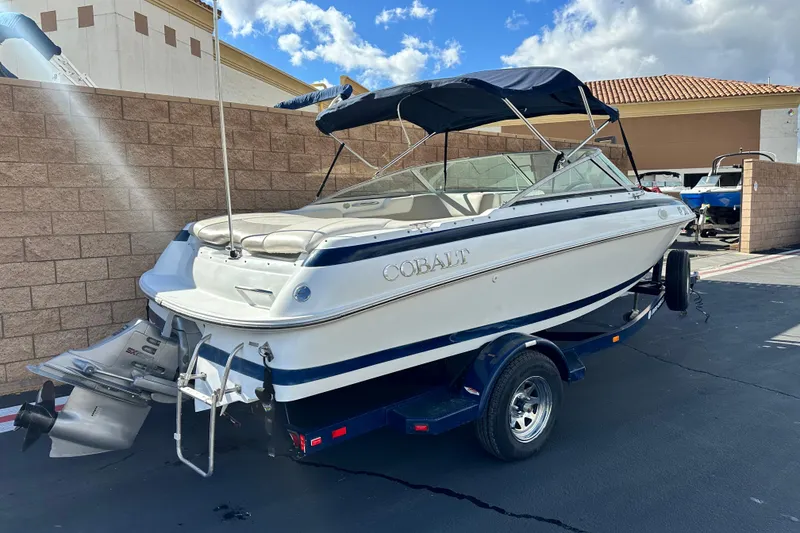 Slide: The Image of 1997 Cobalt 190 boat on trailer, parked outdoors under a blue sky. - 2