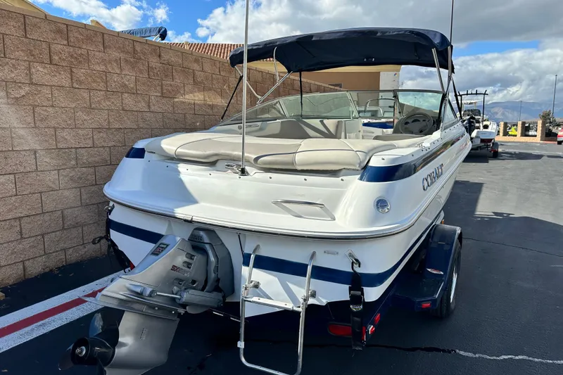Slide: The Image of 1997 Cobalt 190 boat on trailer, parked outdoors under a partly cloudy sky. - 3