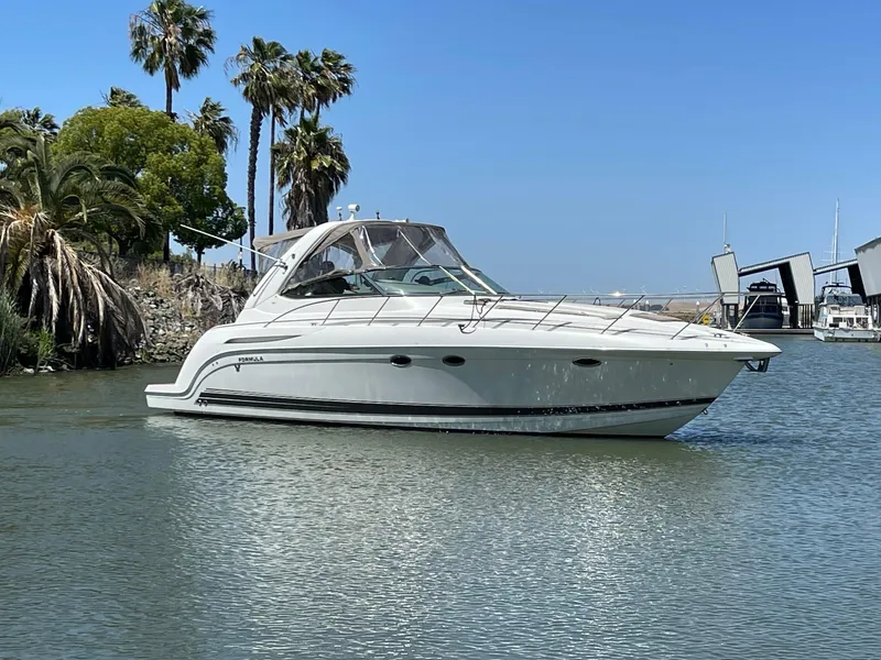 Slide: The Image of 2003 Formula 37 PC yacht cruising on a sunny day with palm trees in the background. - 1