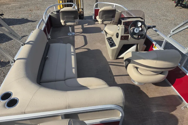 Slide: The Image of 2021 Sun Tracker Bass Buggy 18 DLX pontoon boat interior with beige seating and steering console. - 11
