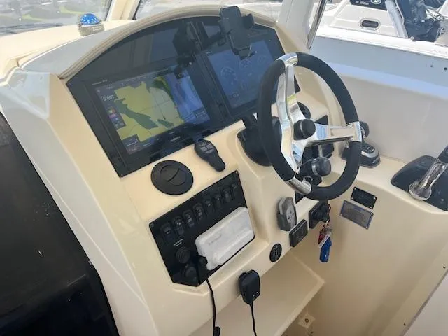 Slide: The Image of 2019 Regal 33 SAV boat dashboard with steering wheel and navigation screens. - 11