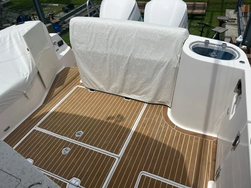 Slide: The Image of 2019 Regal 33 SAV boat deck with wood finish and covered seating area. - 15