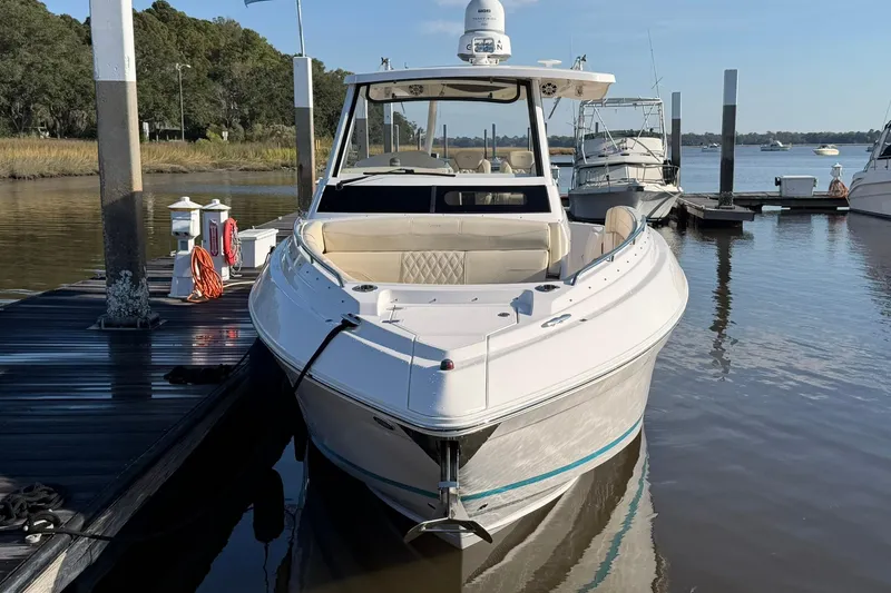 Slide: The Image of 2019 Regal 33 SAV boat docked at marina, calm water, clear sky. - 2