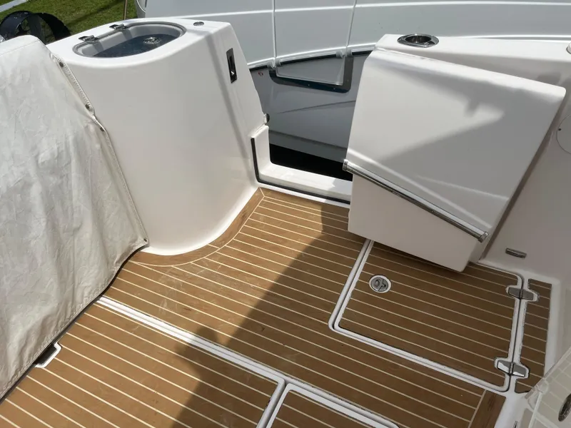 Slide: The Image of 2019 Regal 33 SAV boat deck with wood flooring and storage compartments. - 20