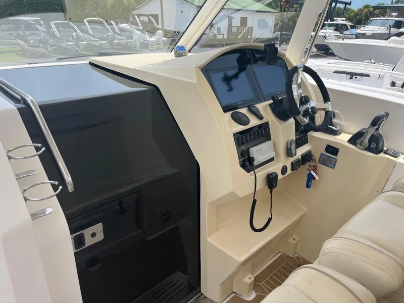 Slide: The Image of 2019 Regal 33 SAV boat cockpit with steering wheel and control panel. - 24