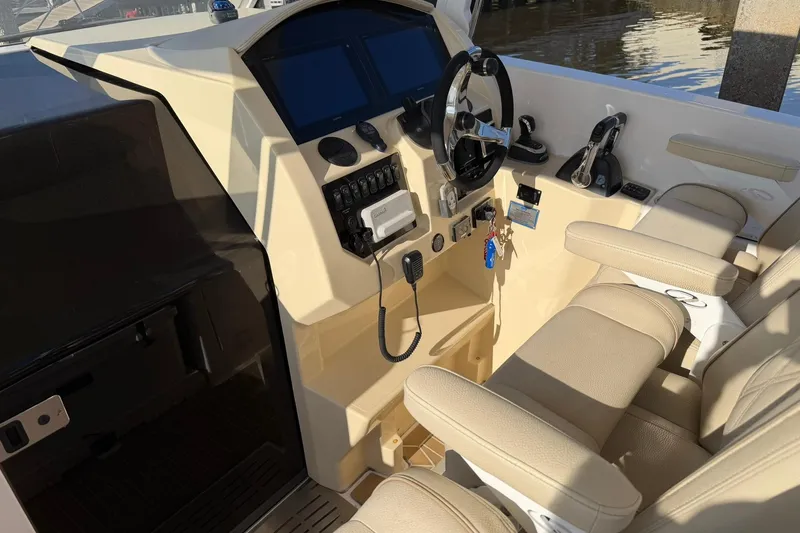 Slide: The Image of 2019 Regal 33 SAV boat cockpit with steering wheel and control panel. - 38