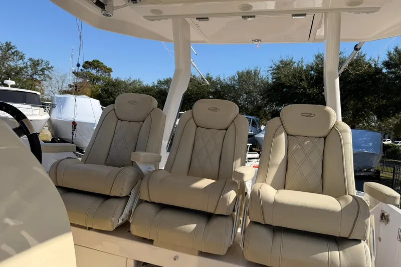 Slide: The Image of 2019 Regal 33 SAV boat with three luxurious beige seats under a canopy. - 40