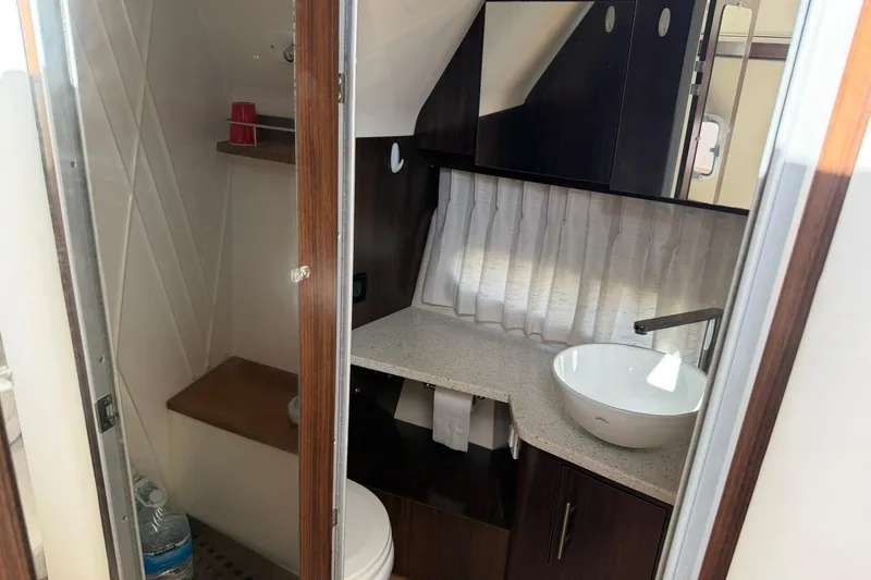 Slide: The Image of 2019 Regal 33 SAV boat bathroom with modern sink and wooden cabinetry. - 43