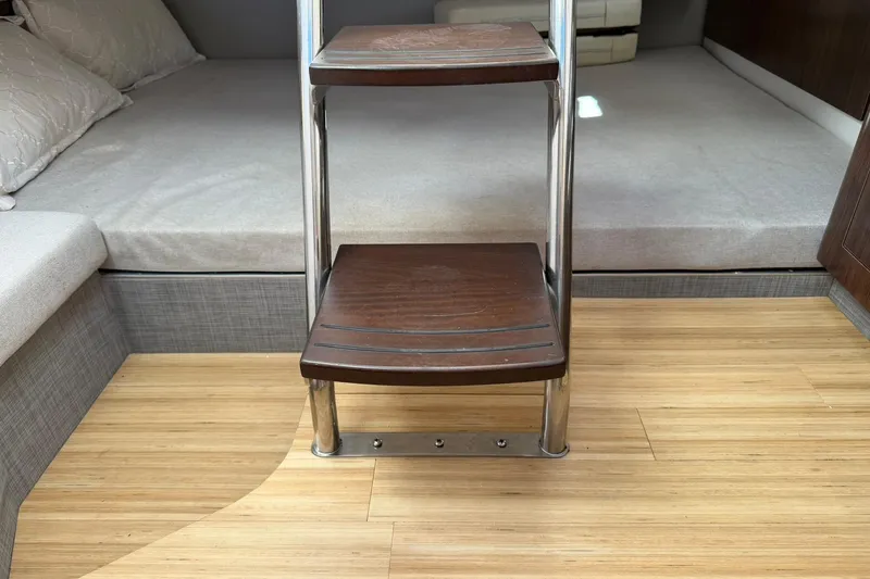 Slide: The Image of Interior of 2019 Regal 33 SAV boat with wooden steps and cozy bedding. - 45