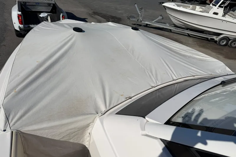 Slide: The Image of 2019 Regal 33 SAV boat covered, parked on trailer near other boats. - 47