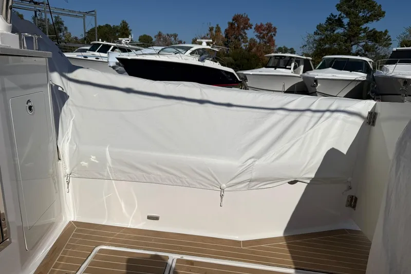 Slide: The Image of 2019 Regal 33 SAV boat deck with protective cover, surrounded by other boats. - 48