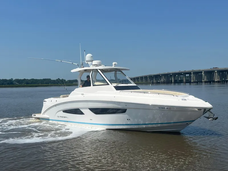 Slide: The Image of 2019 Regal 33 SAV boat cruising on a calm river near a bridge. - 6