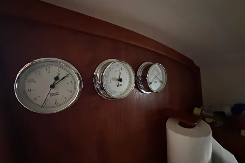 Slide: The Image of Gauges on a 2008 Wasque 26 boat dashboard, featuring clock and barometer. - 13