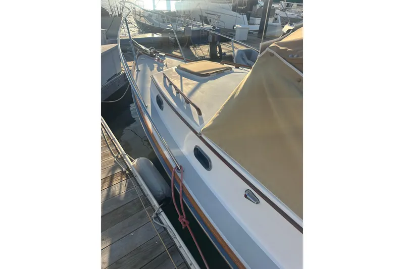 Slide: The Image of 2008 Wasque 26 boat docked at marina, featuring tan cover and sleek design. - 14