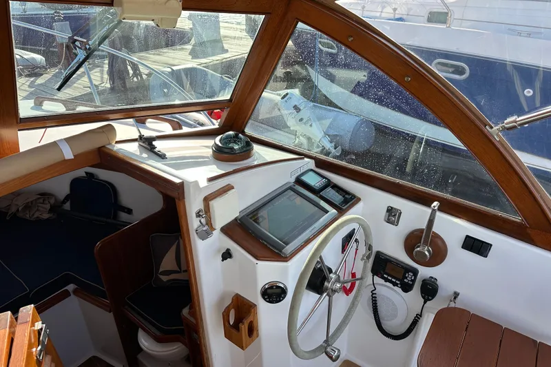 Slide: The Image of 2008 Wasque 26 boat cockpit with steering wheel, navigation instruments, and wooden accents. - 18