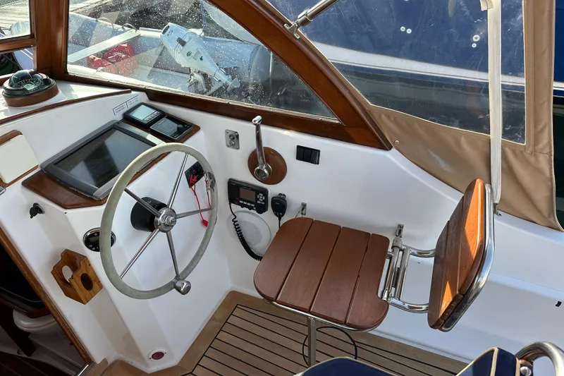 Slide: The Image of Helm of 2008 Wasque 26 boat with wooden accents and navigation equipment. - 19