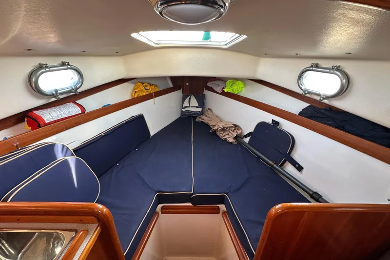 Slide: The Image of Cozy cabin interior of a 2008 Wasque 26 boat with blue cushions and portholes. - 33