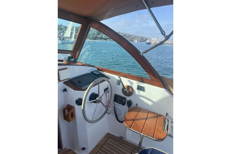 Slide: The Image of Interior view of 2008 Wasque 26 boat cockpit with steering wheel and ocean backdrop. - 34