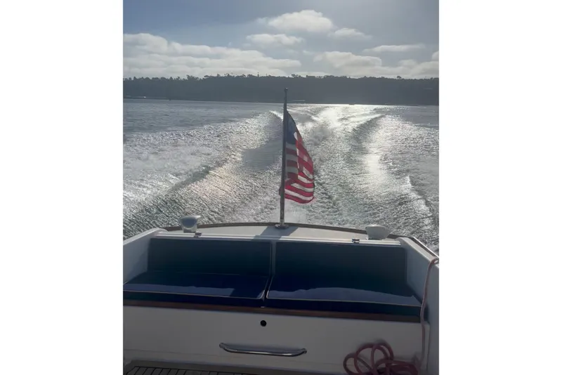 Slide: The Image of 2008 Wasque 26 boat cruising with American flag, leaving a wake on the water. - 38
