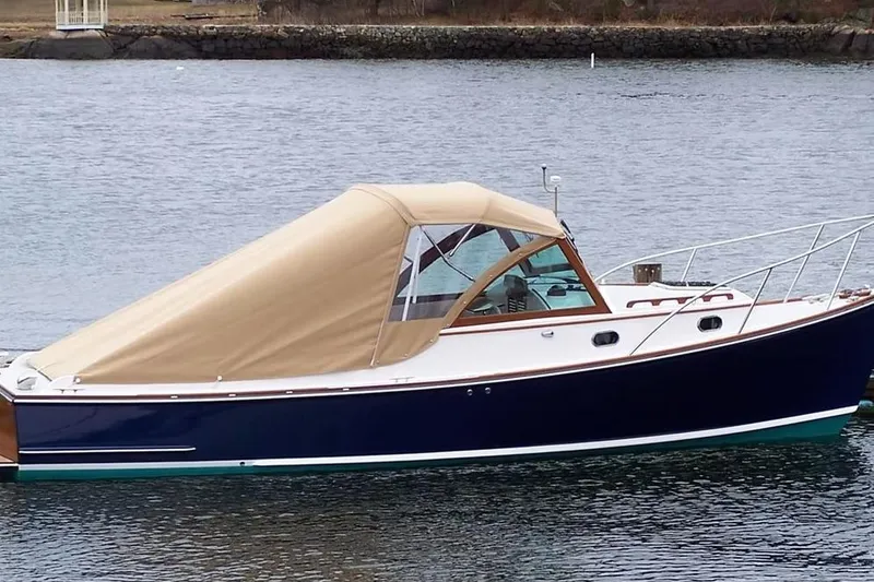 Slide: The Image of 2008 Wasque 26 boat with tan canopy, docked on calm water. - 40