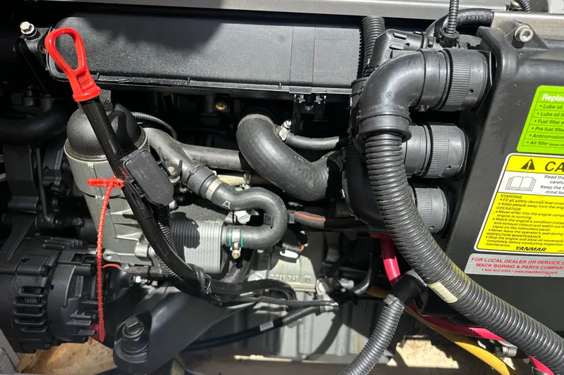 Slide: The Image of Engine compartment of a 2008 Wasque 26 boat, featuring hoses and warning labels. - 45