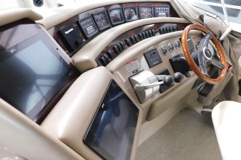 Slide: The Image of 1999 Sea Ray 500 Sundancer helm with gauges, controls, and wood-accented steering wheel. - 12