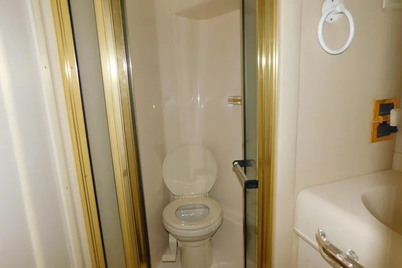 Slide: The Image of Bathroom interior of 1999 Sea Ray 500 Sundancer yacht, featuring toilet and shower. - 24
