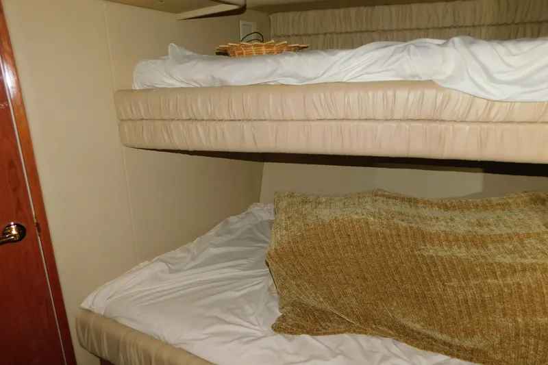 Slide: The Image of Bunk beds in 1999 Sea Ray 500 Sundancer yacht cabin, featuring cozy bedding. - 25