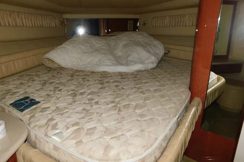 Slide: The Image of 1999 Sea Ray 500 Sundancer cabin with a cozy bed and beige interior. - 27