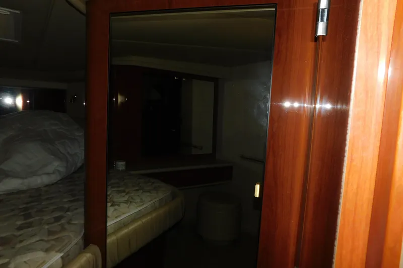 Slide: The Image of 1999 Sea Ray 500 Sundancer cabin interior with wooden finishes and bed. - 28