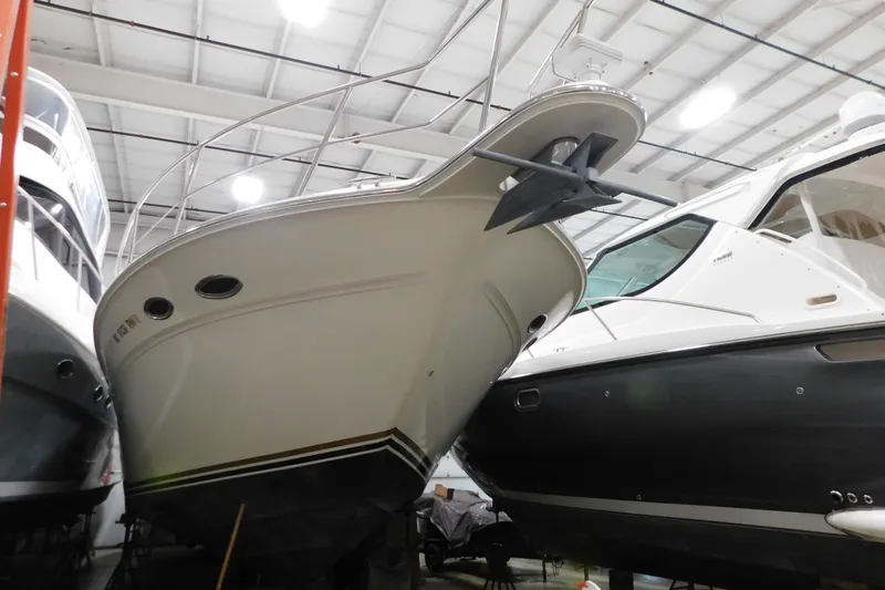 Slide: The Image of 1999 Sea Ray 500 Sundancer yacht in indoor storage, showcasing sleek design and anchor. - 3