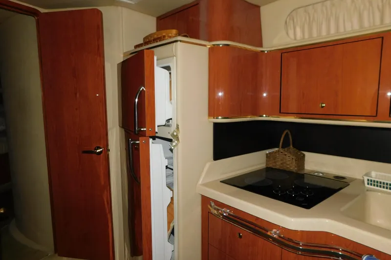Slide: The Image of 1999 Sea Ray 500 Sundancer yacht kitchen with wood cabinetry and modern appliances. - 30