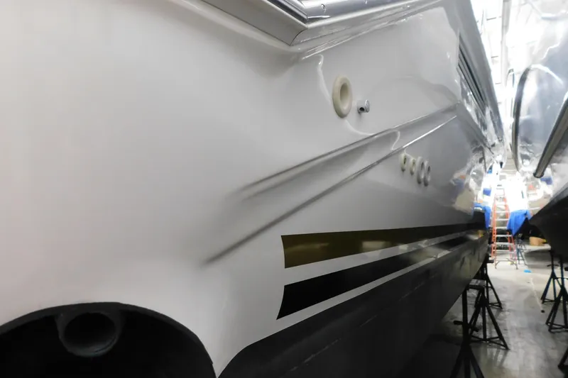 Slide: The Image of 1999 Sea Ray 500 Sundancer boat hull with visible dent, stored indoors. - 38