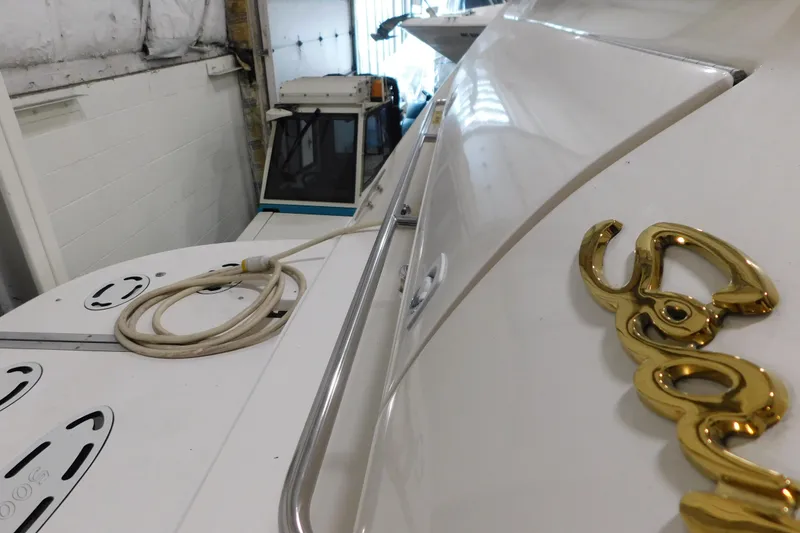 Slide: The Image of 1999 Sea Ray 500 Sundancer yacht in storage, showcasing sleek design and gold emblem. - 5