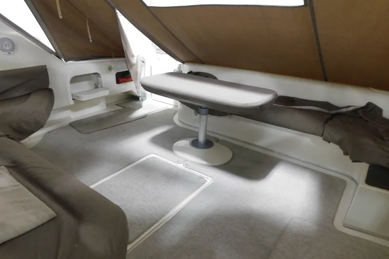 Slide: The Image of 1999 Sea Ray 500 Sundancer interior with seating and table, featuring brown upholstery. - 7