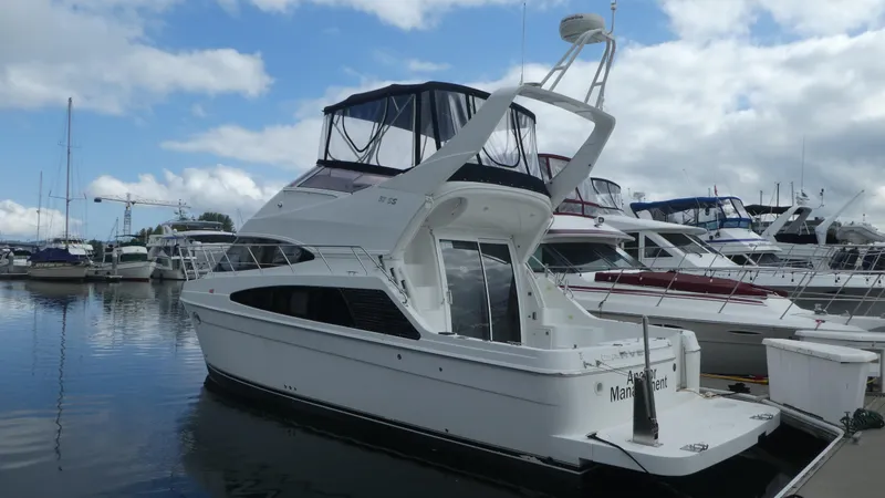 Slide: The Image of 2005 Carver 38 Super Sport yacht docked at marina under cloudy sky. - 1