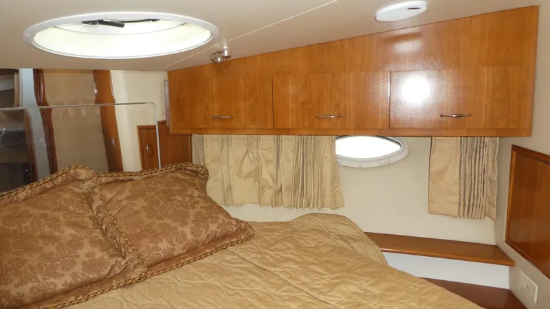 Slide: The Image of Interior of 2005 Carver 38 Super Sport yacht with cozy bedroom and wood cabinetry. - 16