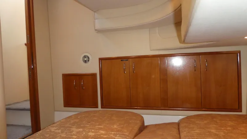 Slide: The Image of Interior cabin of 2005 Carver 38 Super Sport with wooden cabinets and beige bedding. - 24