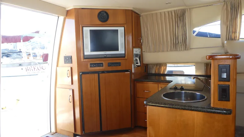 Slide: The Image of Interior of 2005 Carver 38 Super Sport yacht with TV, kitchenette, and wood cabinetry. - 6