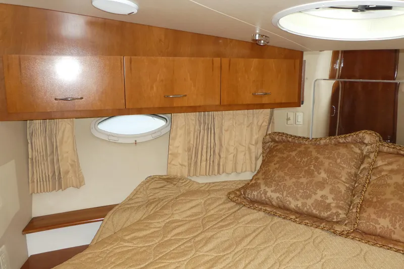 Slide: The Image of Luxurious cabin interior of 2005 Carver 38 Super Sport yacht with wood cabinets and plush bedding. - 17